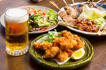 居酒屋で唐揚げやビールが並んでいる写真